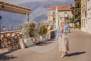 Woman tourist enjoying Colorful street in Old town of Perast on a sunny day, Montenegro. Travel to Montenegro concept