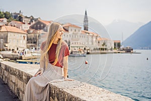 Woman tourist enjoying Colorful street in Old town of Perast on a sunny day, Montenegro. Travel to Montenegro concept