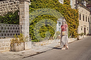 Woman tourist enjoying Colorful street in Old town of Perast on a sunny day, Montenegro. Travel to Montenegro concept