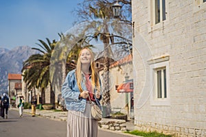 Woman tourist enjoying Colorful street in Old town of Perast on a sunny day, Montenegro. Travel to Montenegro concept