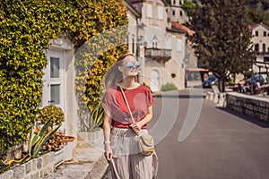 Woman tourist enjoying Colorful street in Old town of Perast on a sunny day, Montenegro. Travel to Montenegro concept