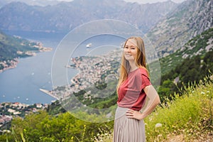 Woman tourist enjoys the view of Kotor. Montenegro. Bay of Kotor, Gulf of Kotor, Boka Kotorska and walled old city