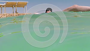 Woman tourist floating in the salt water of the Dead Sea in Israel