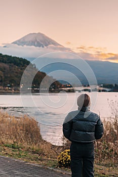 Woman tourist with Fuji Mountain at Lake Kawaguchi, happy Traveler sightseeing Mount Fuji in Fujikawaguchiko, Yamanashi, Japan.