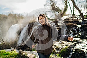 Woman tourist hiker visiting a mountain national park waterfall trail.Adventure tourist exploring nature.Nature and environment