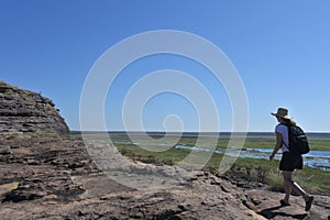 Woman tourist hiking at Ubirr rock art site in Kakadu National Park Northern Territory of Australia