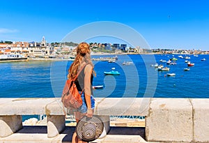 Woman tourist looking at atlantic ocean with boat