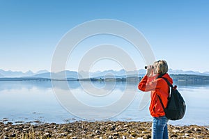 Woman tourist looking through binoculars