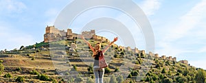 Woman tourist looking at impressive castle in Castile and Leon- Gormaz, Soria province