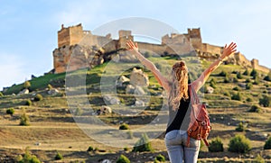 Woman tourist looking at impressive castle in Castile and Leon- Gormaz, Soria province