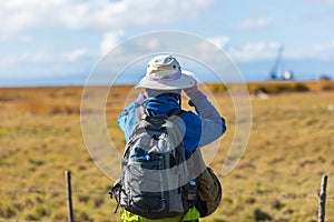 Woman tourist looks through a binoculars into the distance