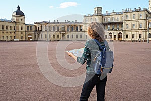 Woman tourist with map on the street. Travel guide, tourism in Europe. The ancient city of Gatchina.