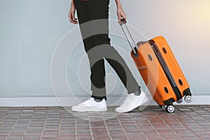 Woman tourist with orange suitcase at station background. travel, tourist, vacation concept