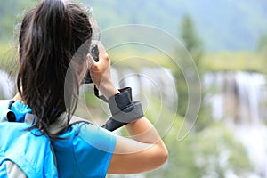 Woman tourist/photographer taking photo with digital camera in jiuzhaigou