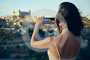 Woman tourist photographing famous landmarks of Toledo. Spain