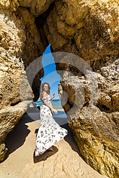 A woman tourist poses on the Praia do Camilo beach of Lagos, Portugal. Algarve region.