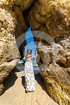 A woman tourist poses on the Praia do Camilo beach of Lagos, Portugal. Algarve region.