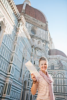Woman tourist showing map while standing near Duomo, Italy