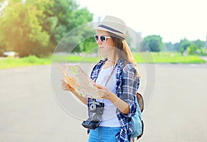 Woman tourist sightseeing city with paper map in summer