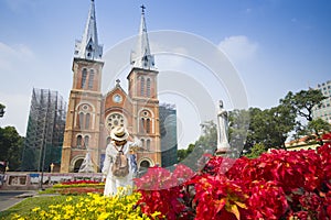 Woman tourist is sightseeing in front of Notre Dame Cathedral of Saigon in Hochiminh City photo