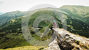 Woman tourist sitting on the background of green mountains and a lake