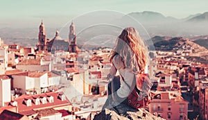 Woman tourist sitting and looking at panoramic view of Jaen city