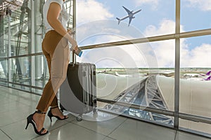 Woman tourist standing with luggage watching sunset at airport w