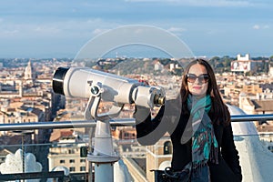Woman tourist is standing near to binoculars on city Rome