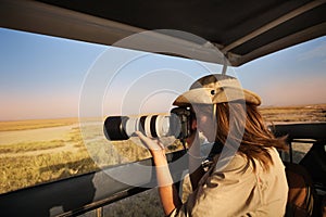 Woman tourist taking photo of African savannah