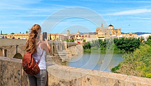 Woman tourist taking picture of Cordoba cathedral, Spain