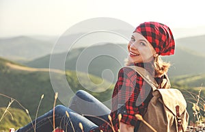 Woman tourist at top of mountain at sunset outdoors during hike