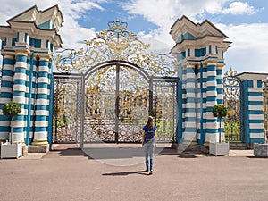 Woman tourist in a tourist spot at the Golden gate of the Grand Catherine Palace in Tsarskoye Selo, Russia