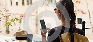 Woman tourist using smartphone at cafe panoramic banner. Traveler girl looking at mobile phone. Travel lifestyle concept