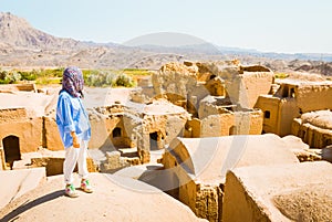 Woman tourist on viewpoint sightseeing Kharanaq, traditional and historic village in Iran