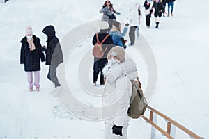 Woman tourist Visiting in Asahikawa, Traveler in Sweater sightseeing Asahiyama Zoo with Snow in winter season. landmark and