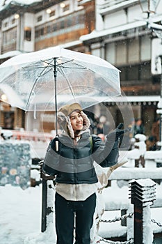 Woman tourist Visiting Ginzan Onsen in Yamagata, happy Traveler sightseeing Japanese Onsen village with Snow in winter season.