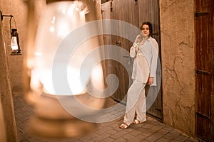Woman tourist walking in Al Seef Meraas Dubai - old historical district with traditional Arabic architecture