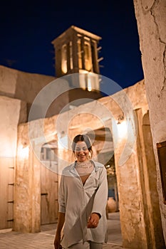 Woman tourist walking in Al Seef Meraas Dubai - old historical district with traditional Arabic architecture