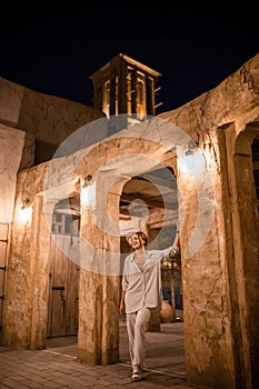 Woman tourist walking in Al Seef Meraas Dubai - old historical district with traditional Arabic architecture