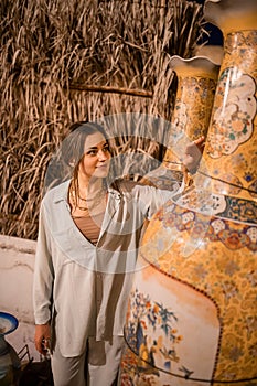 Woman tourist walking in Arab market near Al Seef with crockery, lamps and lanterns in the old style