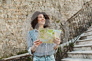 Woman tourist walking on the street in european old city using map