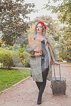 Woman tourist walking with suitcase on the street  in european city, travel background