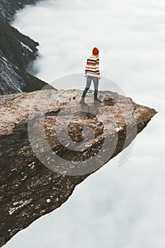 Woman tourist walking on Trolltunga rocky cliff