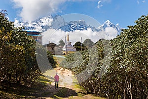 Woman tourist walks alley in Tengboche village, Nepal. photo