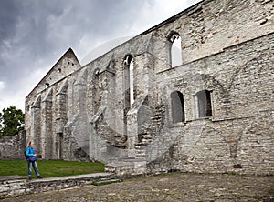The woman the tourist walks about ruined St. Brigitta convent 1436 year in Pirita region, Tallinn, Estonia