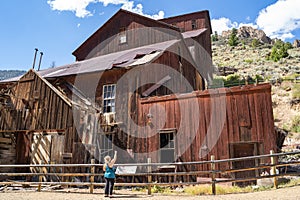 Woman tourists explores the old mining ghost town of Bayhorse Idaho in the Salmon-Challis National Forest