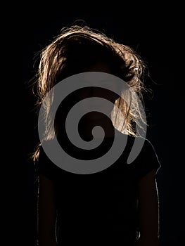 Woman with tousled hair in black shadow photo