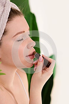 Woman with towel applying makeup