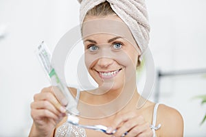 woman in towel brushing teeth photo