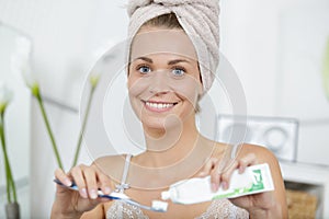 woman with towel on head going to brush teeth